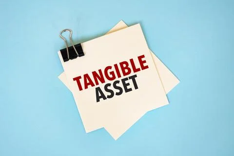 Text tangible asset on sticky notes with copy space and paper clip isolated.. Stock Photos