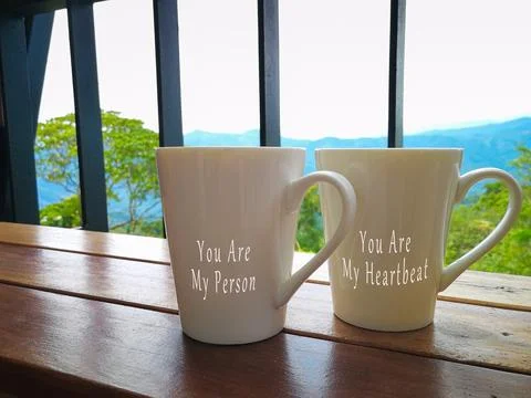 Text on two porcelain cups facing the mountain view Stock Photos
