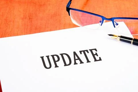 Text UPDATE an inscription on a white sheet on the table near glasses and a.. Stockfoto's