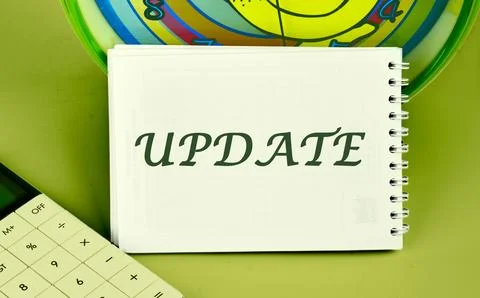 Text UPDATE on a notepad on the background of a clock next to a calculator Stockfoto's