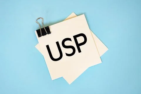 Text USP on sticky notes with copy space and paper clip isolated on red bac.. Foto stock