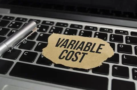 Text VARIABLE COST on white paper on clipboard with chart and calculator Stock-Fotos