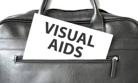 Text VISUAL AIDS writing on white paper sheet in the black business bag. Bu.. Stock Photos