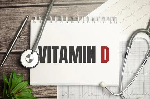 Text VITAMIN D on notebook with stethoscope and pen on wooden background Stock Photos