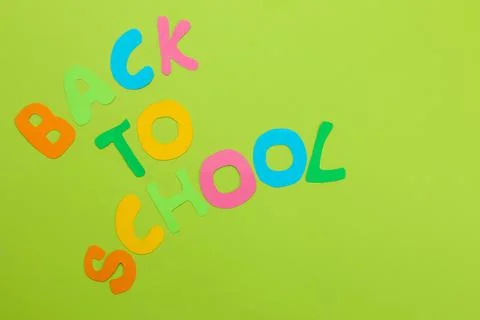 The text will return to school from multi-colored letters on a bright green b Stock Photos