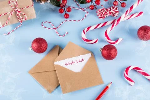 Text Wish List. Envelope, paper card and decoration on blue table top view. Stock Photos