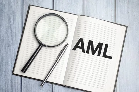 Text written in brown diary AML Anti-Money Laundering and magnifier Stock Photos