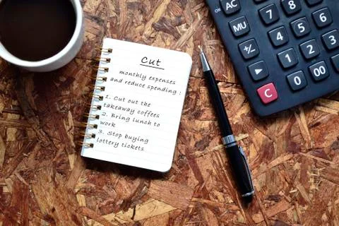 Text written on note pad with background of cup of coffee ,a pen and calculat Stock Photos