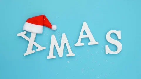 Text Xmas from volume white letters in red Santa hat and falling snow Stock Footage 112860159