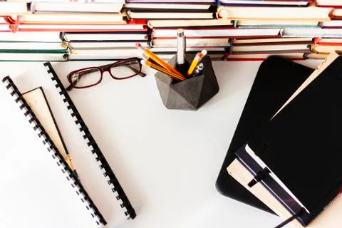 Textbook, laptop, glasses, stack piles of literature, bookshelves in office Stock Photos