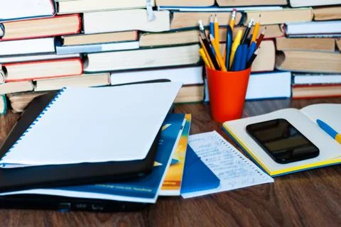 Textbook, notebook, laptop computer, mobile phone smartphone, stack of books. Stock Photos