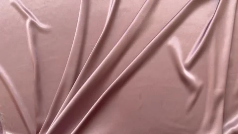 Textile abstract background of soft pink satin fabric with folds and drapes Stock Footage 306561047