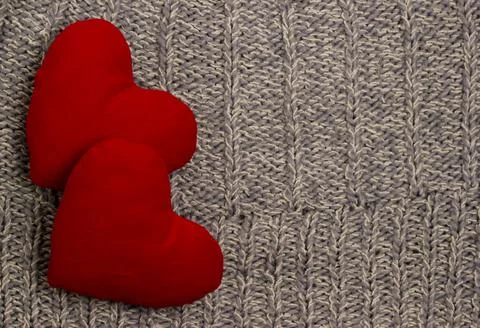Textile background. Two red hearts on the soft knitted blanket. Valentines da Stock Photos
