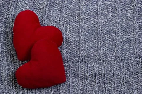 Textile background. Two red hearts on the soft knitted blanket. Valentines da Stock Photos