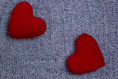 Textile background. Two red hearts on the soft knitted blanket. Valentines da Stock Photos