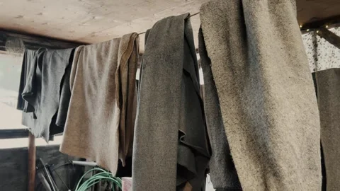 Textile fabrics hanging inside rustic workshop or storage room Stock Footage 323771689
