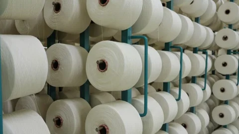 Textile factory equipment, Large thread spools hang on a metal racks close-up Stock Footage 271616148