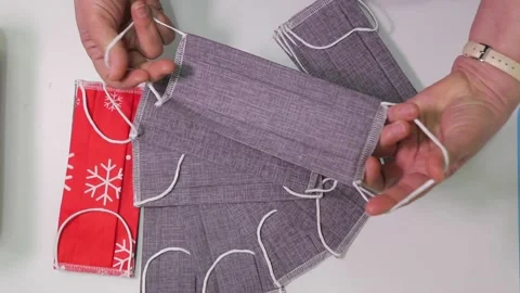 Textile factory worker checking many finished fabric masks Video stock 168580356