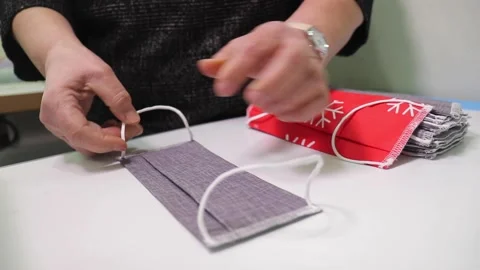Textile factory worker checking many finished fabric masks Stock Footage 168644001