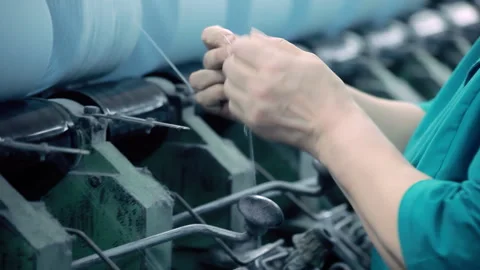 Textile factory worker hands tying yarn thread. Close up spinning machine mill. 動画素材 345920162
