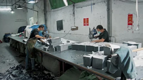 Textile Factory Workers Cut Layers of Fabric Using Industrial Tool Stock Footage 337917744