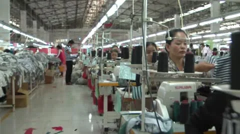 Textile Garment Factory Workers: Steadicam-like glide past rows workers Stock Footage