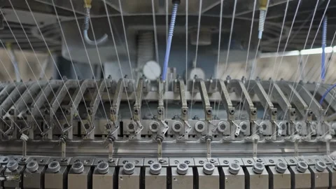 Textile knitting machine feeding multiple threads in factory Stock Footage 327451019