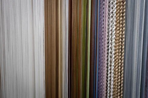 Textile strings and ropes hangs in a fabric shop. Abstract background. Stock Photos