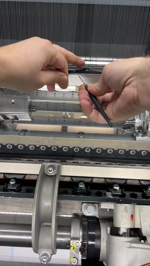 A textile worker repairs a thread break on a knitting machine Video stock 312169397