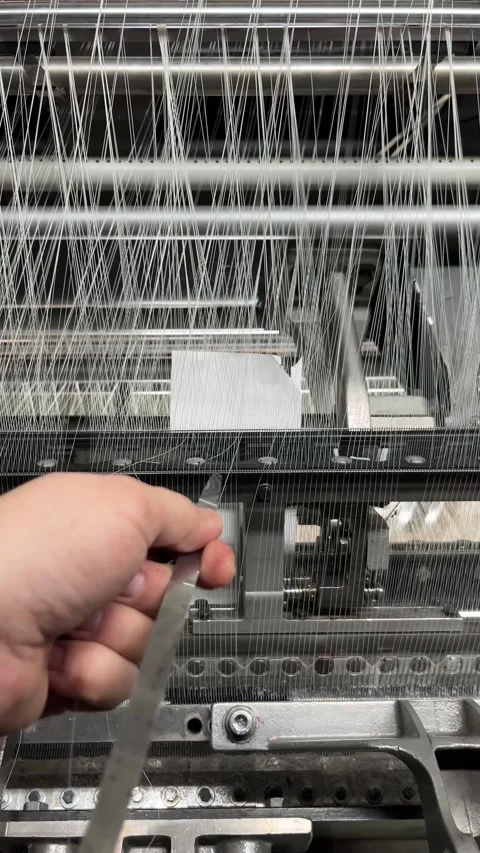 A textile worker repairs a thread break on a knitting machine Stock Footage 312171106