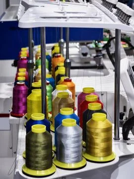 In a textile workshop, many spools of bright thread are neatly arranged on a  Stock Photos