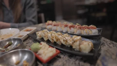 Texting in background panning sushi rolls Stock Footage 305791986