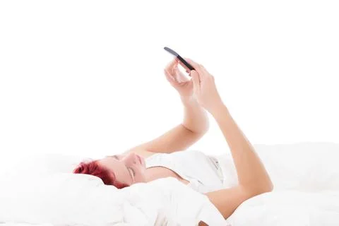 Texting in bed Stock Photos