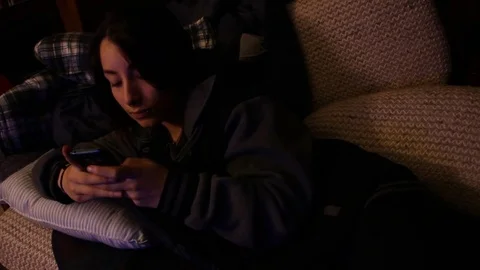 Texting instead of watching TV Stock Footage 78955436