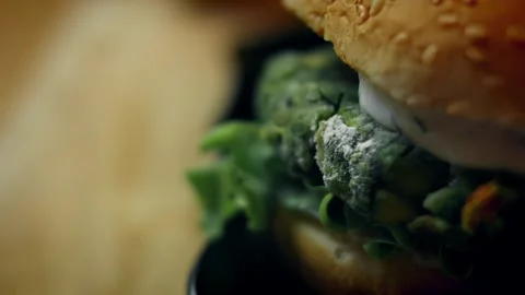 Textural gloved hands assembling a spinach patty sandwich in tabletop, 4K Stock Footage 341111305