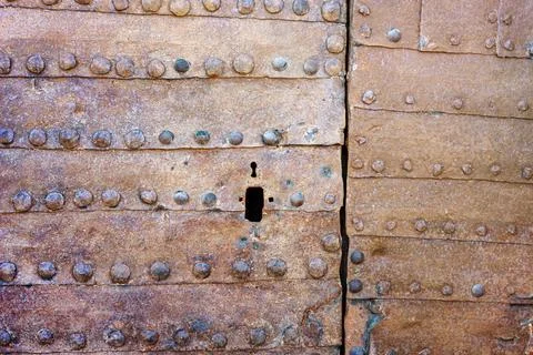 Texture of an ancient rusty iron door with rivets and keyhole Stock Photos