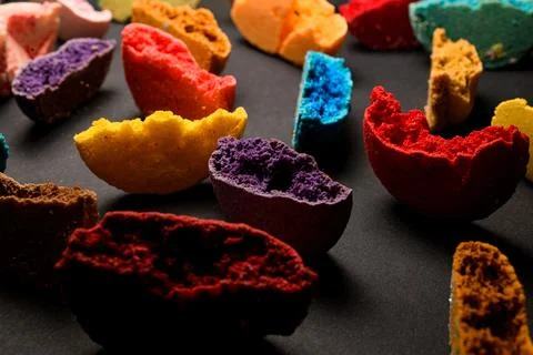 Texture of appetizing multicolored halves of macaroons broken and bite on black Stock Photos