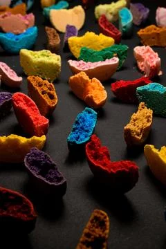 Texture of appetizing multicolored halves of macaroons broken and bite on black Stock Photos