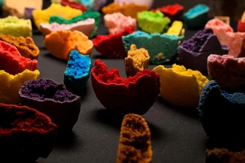 Texture of appetizing multicolored halves of macaroons broken and bite on black Stock Photos