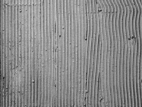 Texture applied tile adhesive on wall, ribbed concrete background close-up. Stock Photos