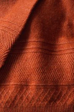 Texture of an autumn knitted sweater with pattern. Autumn cozy background. Stock Photos