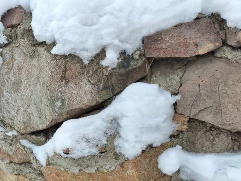 Texture background masonry under cover of white snow stone fence Stock Photos