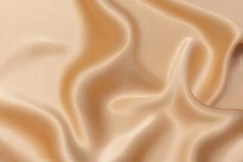 Texture, background, pattern. Texture of light beige or peach color silk or c Stock Photos