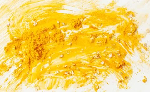 Texture background of a smeared face mask made of turmeric Stock Photos