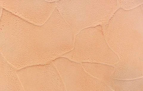 Texture of beige decorative plaster on the wall in the interior of the room. Stock Photos