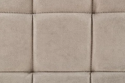 Texture beige fabric. Background of a soft pouf. Stock Photos