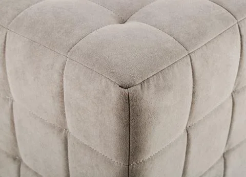 Texture beige fabric. Background of a soft pouf. Stock Photos