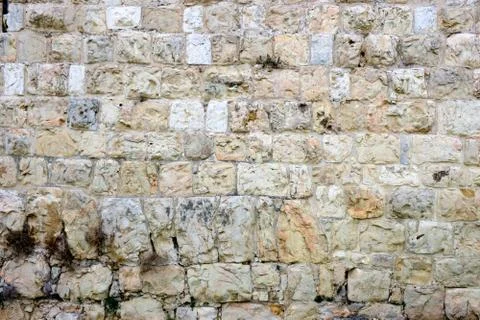 Texture of a beige-gray wall composed of stones Stock Photos