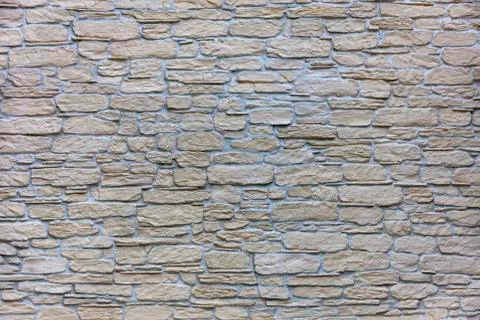 Texture of a beige stone wall of a large cobbled stone close-up Stock Photos