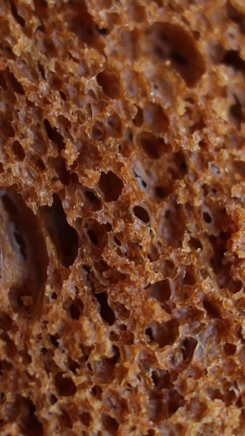 Texture of black bread rotating extreme close up, macro shot. Vertical video. Stock Footage 269311720